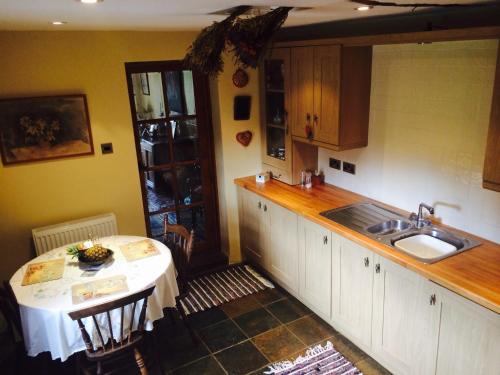 a kitchen with a table and a sink and a counter at Low Nook Farm Holiday Cottage in Brampton