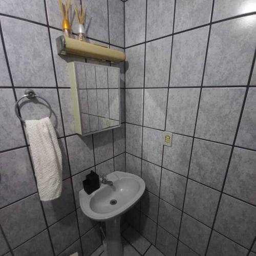 a small bathroom with a sink and a mirror at Canto de paz in Brusque