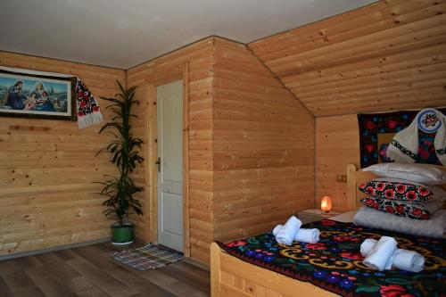 a bedroom with a bed in a log cabin at Casa Vladicu in Breb