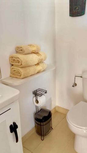 a bathroom with a toilet and a stack of towels at Villa Jardin De l'Ocean in Aourir