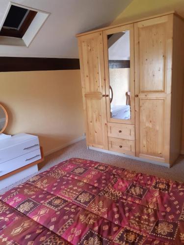 ジェラールメにあるAppartement Le Parad'hiverのベッドルーム1室(キャビネット、赤い敷物付きのベッド1台付)
