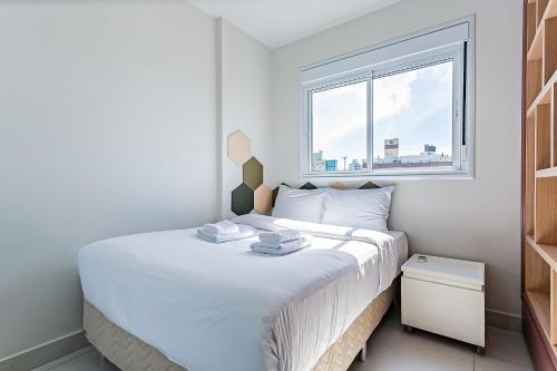 1 dormitorio blanco con 1 cama grande y ventana en Churrasqueira | Vista parcial do MAR #CA32, en Florianópolis