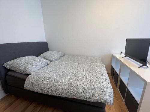 a bedroom with a bed and a desk with a television at Modernes Apartment 2 in Bad Kreuznach mit einfachem Self-Check-in in Bad Kreuznach