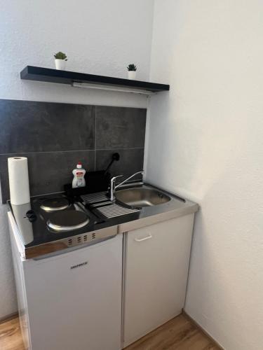 a small kitchen with a sink and a stove at Modernes Apartment 2 in Bad Kreuznach mit einfachem Self-Check-in in Bad Kreuznach