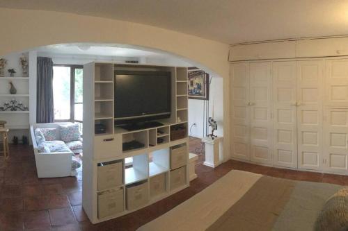a living room with a large entertainment center with a television at Encantador loft! por el lago in Juriquilla