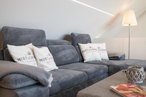 a living room with a blue couch with white pillows at Familien- und Aparthotel Strandhof in Butjadingen OT Tossens