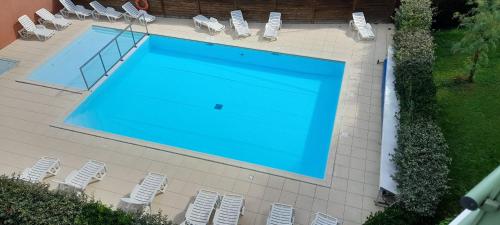 - une vue sur la piscine et ses chaises dans l'établissement Appart pour 4 - Piscine - Au coeur de La Chaume, à Les Sables-dʼOlonne