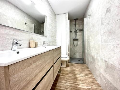 Arenales del Sol Beach Apartment في آريناليس ديل سول: حمام مع حوض أبيض ومرحاض