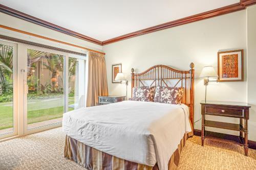 a bedroom with a bed and a large window at Waipouli Beach Resort H105 in Kapaa