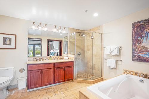 a bathroom with a tub and a shower and a sink at Waipouli Beach Resort H105 in Kapaa