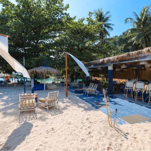 a sandy beach with chairs and tables and umbrellas at Rest Sea Resort Koh Kood in Ko Kood