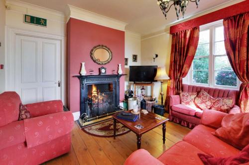 a living room with red furniture and a fireplace at Robin Hill House Heritage Guest House in Cobh