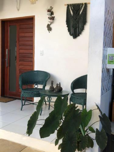 a patio with two chairs and a table and a door at Pousada Paracuru Surf in Paracuru