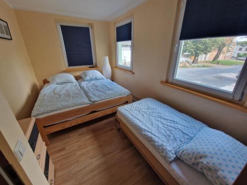 twee bedden in een kleine kamer met een raam bij Familienfreundliche Fewo MV Malchin in Malchin