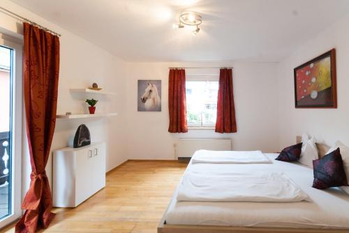 een slaapkamer met twee bedden en een raam bij Appartments Zell am See in Zell am See