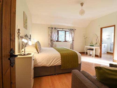 a bedroom with a bed and a living room at Ty Newydd in Dolanog