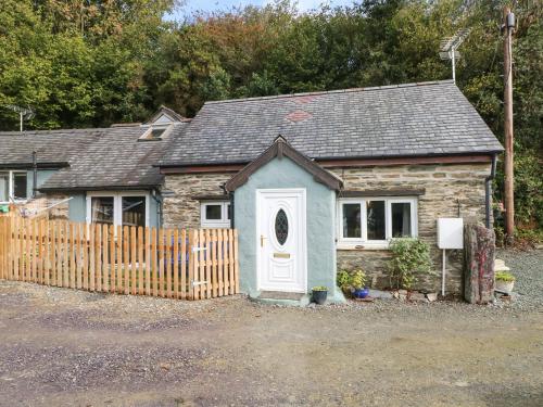 a small house with a fence in front of it at Pendre Cottage in Llanfyrnach