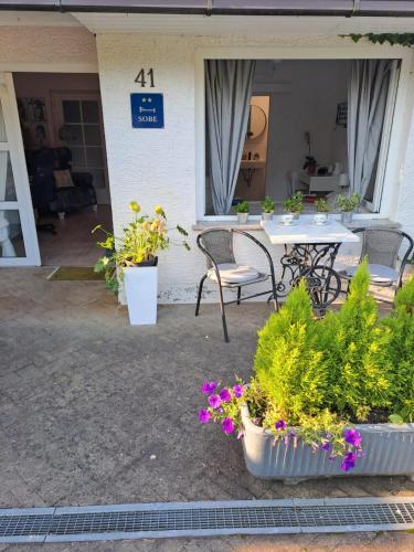 a patio with a table and chairs and flowers at Soba Dvori in Zaprešić