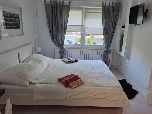a bedroom with a white bed and a window at Soba Dvori in Zaprešić