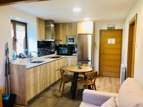 a kitchen with a table and chairs in a room at Apartamentos Zabalarena Artzaia in Orbaiceta