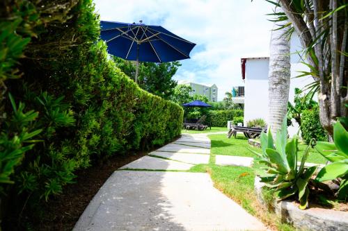 a path with a blue umbrella and a bench and sidx sidx sidx at Sandpiper Apartments in Mount Pleasant