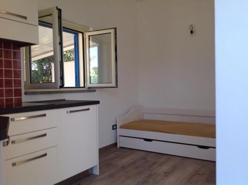 ソヴェラート・マリーナにあるItalian Breezeのベッドと窓が備わる小さな客室です。
