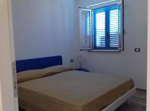 a white bedroom with a bed and a window at Italian Breeze in Soverato Marina
