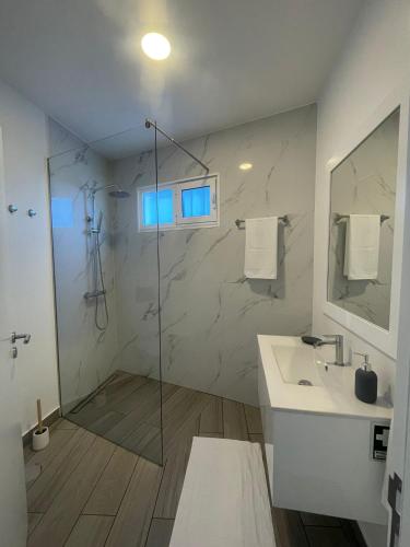 a bathroom with a glass shower and a sink at Tides proprety - Low tide in Paul do Mar