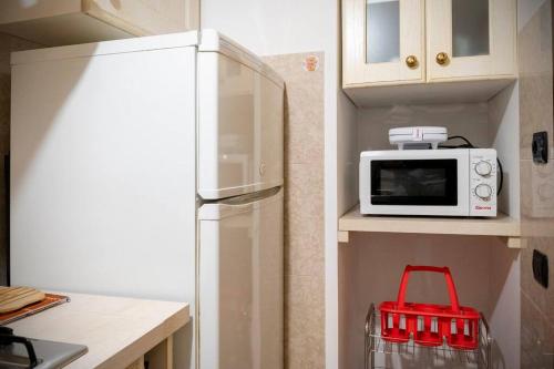 a kitchen with a refrigerator and a microwave at La Via per Tharros in Oristano