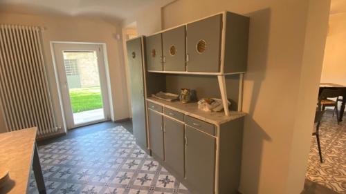 a room with green cabinets and a table and a door at Affittacamere Valèt in San Marzano Oliveto