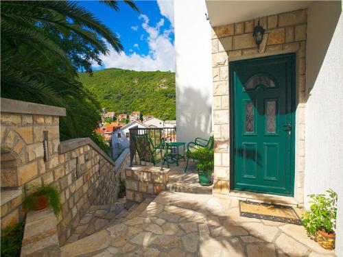 a green door on a house with a patio at Klaris Guest house in Budva