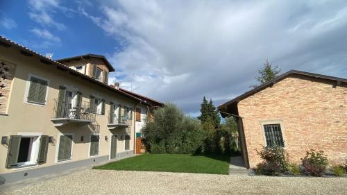 a large brick building with a yard in front of it at Affittacamere Valèt in San Marzano Oliveto