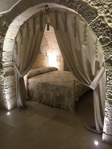 a bedroom with a bed in a stone wall at TRULLI LE 2 NICCHIE in Locorotondo
