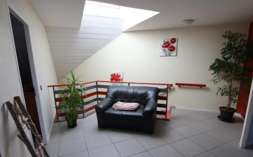 a black leather chair in a room with plants at Les 3 Edelweiss - GITE 1 OU GITE 2 in Arette