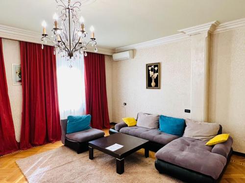 a living room with two couches and a chandelier at Superb Central Location! Spacious and Comfortable 1 Bedroom + Jacuzzi, Next To Northern Avenue in Yerevan