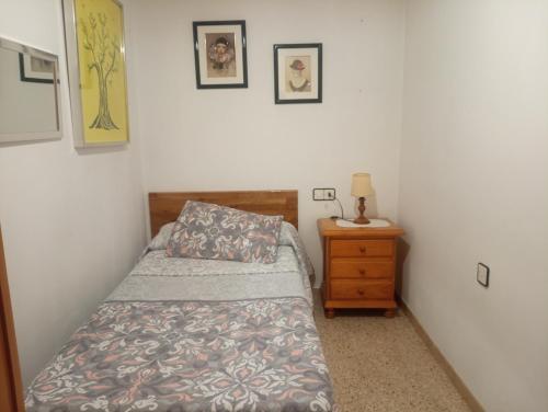 - une petite chambre avec un lit et une table de nuit dans l'établissement Can Molone, à Cornudella de Montsant
