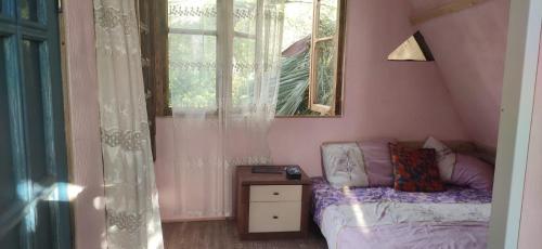 a small bedroom with a bed and a window at Деревенский домик in Chakvi
