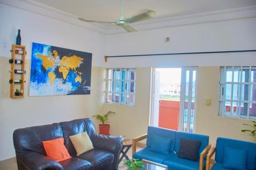 a living room with two blue chairs and a couch at Agim-Cotonou in Cotonou