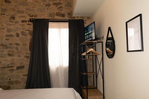 a bedroom with a black curtain and a window at Ecolagar O Barqueiro in Pantón