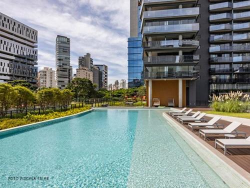 a swimming pool with lounge chairs and a building at Studio luxuoso com vaga no Itaim Bibi - VN 1307 in São Paulo