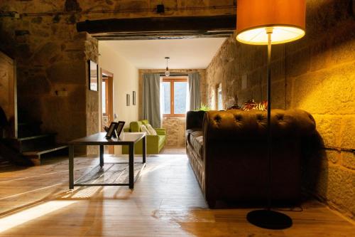 a living room with a couch and a table at Ecolagar O Barqueiro in Pantón