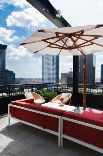 a patio with a table and an umbrella on a roof at Virgin Hotels New Orleans in New Orleans