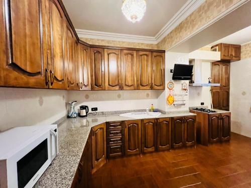 a kitchen with wooden cabinets and a sink at Superb Central Location! Spacious and Comfortable 1 Bedroom + Jacuzzi, Next To Northern Avenue in Yerevan