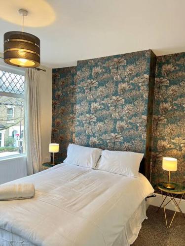 a bedroom with a large white bed with a brick wall at Holiday Home in Walthamstow in London