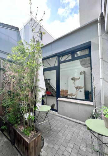 un patio avec une table, des chaises et une fenêtre dans l'établissement LOFT, à Montreuil