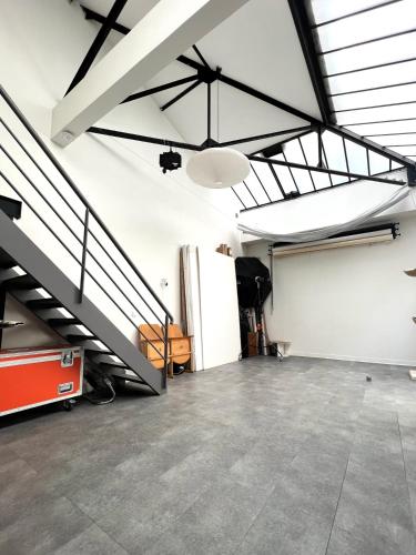 une pièce vide avec un escalier en mezzanine dans l'établissement LOFT, à Montreuil