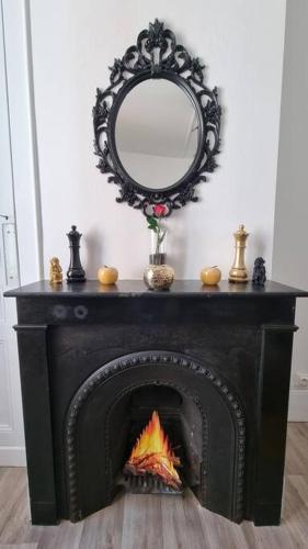 Elle comprend une cheminée avec un miroir. dans l'établissement Chez K&D Studio Jaune Le Havre, au Havre