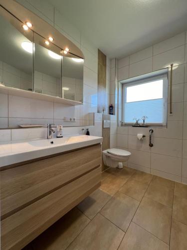 a bathroom with a sink and a toilet at Schöne Ferienwohnung im Grünen - 5 Minuten vom Schloss Dankern entfernt in Haren