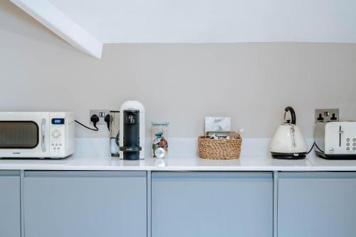 encimera de cocina con microondas y electrodomésticos en Spring Grove Apartment - Central Harrogate en Harrogate