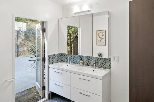 a bathroom with a white sink and a mirror at Hillside Canyon, Private Home W/ Pool and Nature in Los Angeles